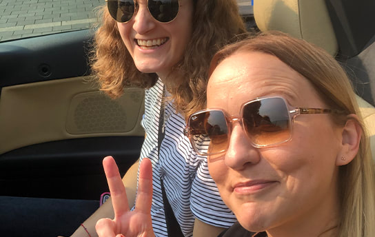 Zwei Mitarbeiterinnen lächeln in die Kamera